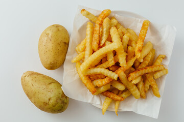 Delicious Golden Crinkle Cut French Fries and Fresh Raw Potatoes