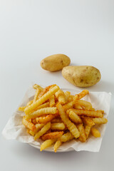 Crinkle Cut French Fries with Potatoes on White Background