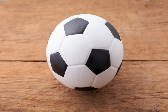 Classic Black and White Soccer Ball on Rustic Wooden Surface