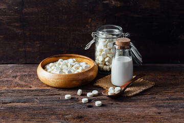 Milk and White Candy on Wooden Table with Rustic Background