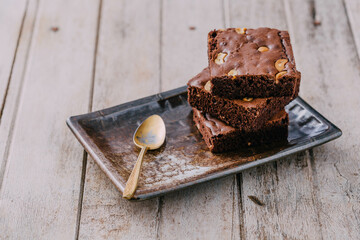 Delicious Brownie Squares with Nuts on Stone Plate and Spoon
