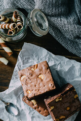 Delicious Chocolate Brownies with Nuts on Crumpled Paper Background