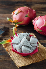 Fresh Dragon Fruit Slices in Pink Skin on Rustic Wooden Table