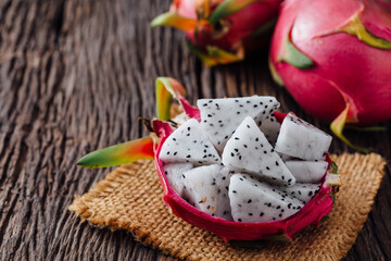 Fresh Dragon Fruit Pieces on Rustic Wooden Table with Whole Fruit