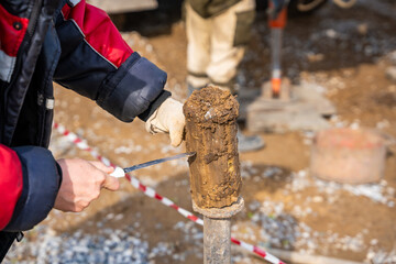 Man cutting and cleaning soil sample for laboratory analysis. Preparation of core material for...