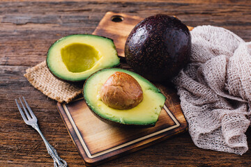 Fresh Avocado Halved on Wooden Cutting Board with Rustic Background