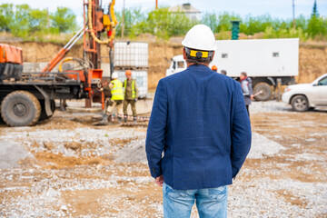 Supervisor overseeing soil sampling and pile drilling process on construction site. Responsible specialist ensuring quality control and compliance during geotechnical operations