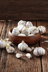 Fresh Garlic Cloves in Wooden Bowl on Rustic Wooden Table