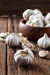 Fresh Garlic Cloves on Rustic Wooden Table with Bowl Background