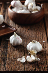Fresh Garlic Cloves in Wooden Bowl on Rustic Wooden Table