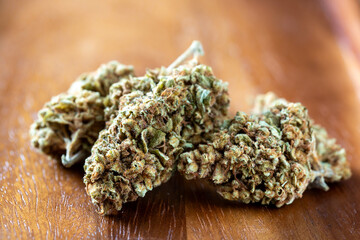 Close up view of natural cannabis buds on wooden surface