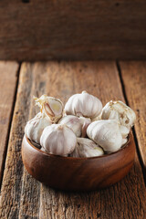 Fresh Garlic Bulbs in Wooden Bowl on Rustic Wooden Background