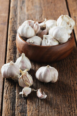 Fresh Garlic Bulbs with Wooden Bowl on Rustic Wooden Surface