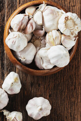 Fresh Garlic Cloves in Wooden Bowl on Rustic Wooden Surface