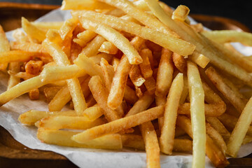 Crispy Golden French Fries on Wooden Tray with White Paper