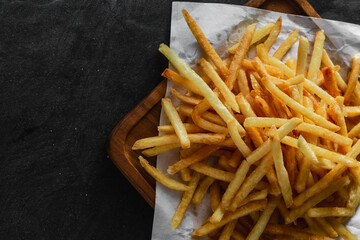 Freshly Cooked Golden French Fries on Black Background Surface