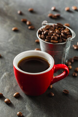 Freshly Brewed Coffee in Red Cup with Coffee Beans in Background