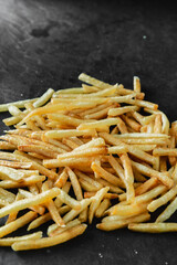Golden Crispy French Fries Stacked on Dark Background for Snack Lovers