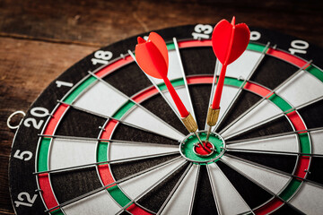 Darts Hitting the Bullseye on a Wooden Dartboard Game