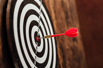Red Dart Striking the Bullseye on a Circular Target Board