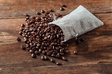 Coffee Beans Spilled from Natural Fabric Bag on Rustic Wooden Table