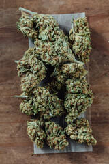 Dry cannabis buds on a wooden surface for herbal medication use