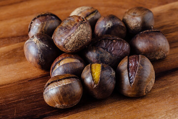 Freshly Roasted Chestnuts Piled on Wooden Table Surface