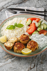 Chicken meatballs with sun-dried tomatoes, feta cheese and aromatic spices served with lemon rice...