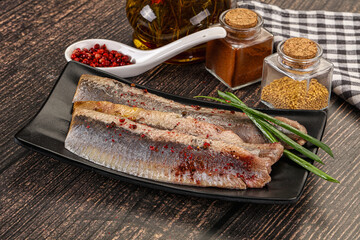 Salted marinated herring fillet with spices
