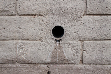 Water Dripping from Drain in Painted Bricks