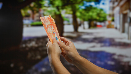 Man holding philippine pesos on an urban street suggests a concept of business, investment, and...