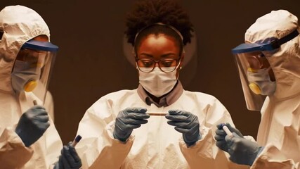 A team of medical personnel wearing complete personal protective equipment (PPE) including masks, gloves, and face shields while in an isolation room. This scene shows infection control protocols and 
