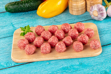 Raw beef meatballs over board