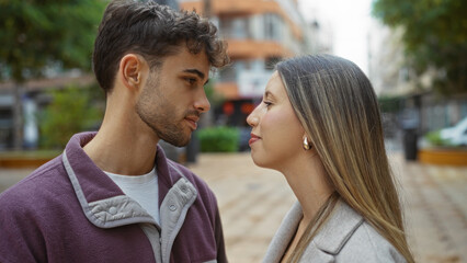 Fototapeta premium Man and woman stand face-to-face in urban setting, showcasing their love and connection amidst the bustling city atmosphere, embodying modern relationship in exterior backdrop.