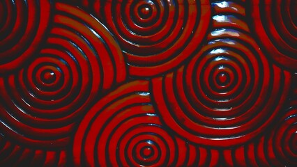 Abstract pattern featuring glossy red concentric circles with dark blue outlines, creating a swirling, hypnotic, and textured visual effect.