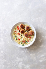 Orzo pasta with chicken meatballs, tomatoes and herbs. Italian food.