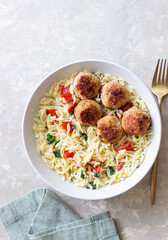 Orzo pasta with chicken meatballs, tomatoes and herbs. Italian food.