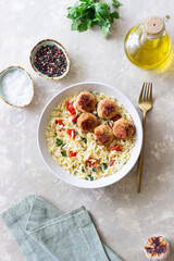 Orzo pasta with chicken meatballs, tomatoes and herbs. Italian food.