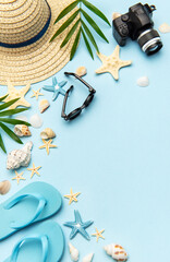 Summer accessories creating frame on light blue background with copy space