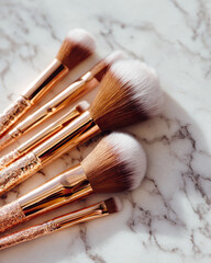 Flat lay of rose gold makeup brushes arranged on marble surface, showcasing their elegant design and soft bristles, perfect for beauty enthusiasts and makeup artists