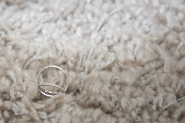 two golden silver wedding rings on white carpet textile for marriage couple background
