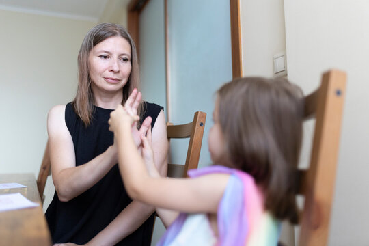 Speech therapist helping child with sign language at home