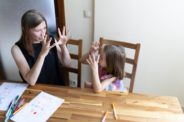 Mother and daughter communicating using sign language at home