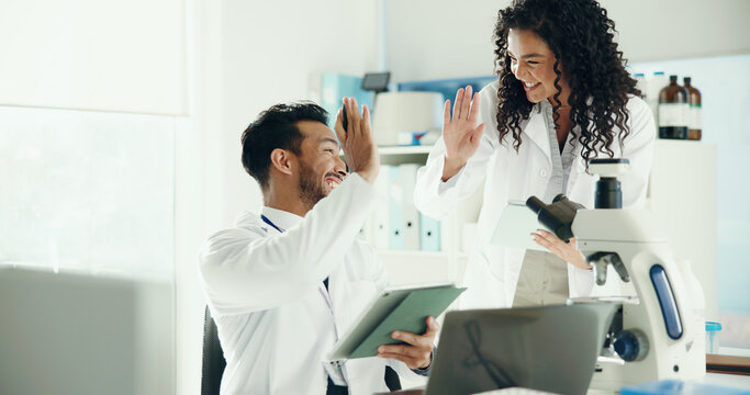 Scientist, people or high five with tablet in lab for clinical trial success, test results and goals. Science, teamwork or celebration for medical research, breakthrough or pharmaceutical development