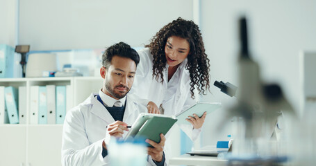 Science, talking and people on tablet in lab with microscope for analysis, medical research and study. Biology, pharmaceutical team and man with woman on tech for results, review and online report