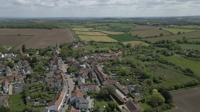 Arial view of Stogursey parish in the quantock hills Somerset. Drone rotating to the right over the village buildings in direction to the green fields that surround the village.