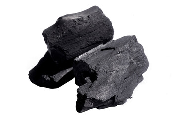 Black charcoal lumps placed on a white background.