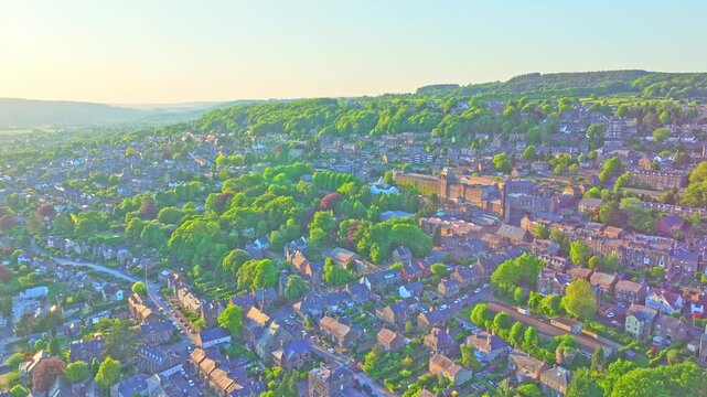 Drone captures Matlock Sparrow Park, Derbyshire, England, with hillside woods, classic rooftops, and clustered stone buildings, displaying the blend of nature and village heritage from above, aerial