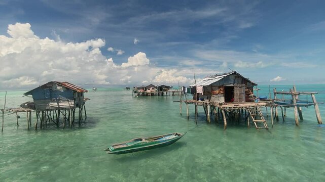 Traditional stilt houses stand gracefully above the crystal-clear waters off the coast of Semporna, Sabah, showcasing the simple, beautiful life of the sea gipsy nomads.