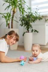 Older Sibling Playing With Baby on Carpet. Tummy time